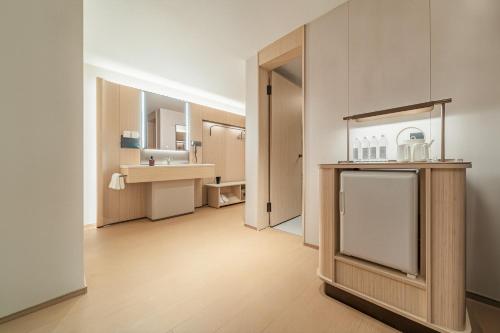 a large bathroom with a sink and a refrigerator at Ji Hotel Phnom Penh Downtown in Phnom Penh
