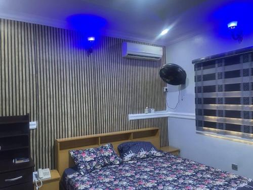 a bedroom with a bed with blue lights on it at Muniz Apartments in Lagos