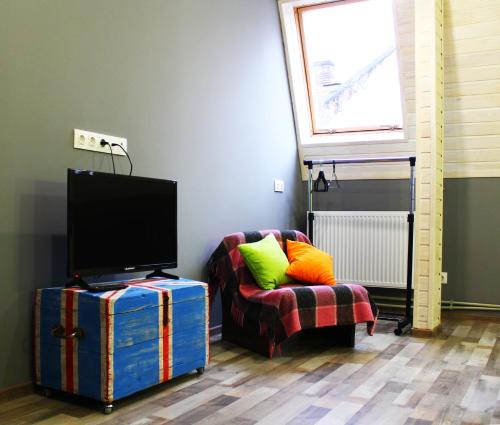 uma sala de estar com uma cadeira e uma televisão em Lviv Loft Apartments em Lviv
