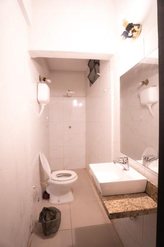a white bathroom with a toilet and a sink at Boutique 1970 Hotel in Asunción