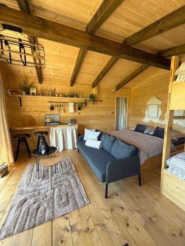 a bedroom with a bed and a couch in a room at Treetop Tiny House Pod Korunami in Horná Mičiná
