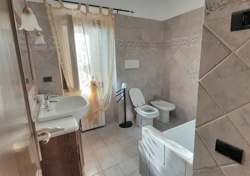 a bathroom with a sink and a toilet and a tub at Le Maree Susanna in Rio Marina