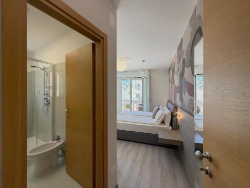 a bathroom with a bed and a bath tub next to a window at Hotel Universal in Caorle