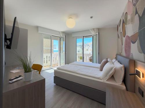 a bedroom with a bed and a large window at Hotel Universal in Caorle