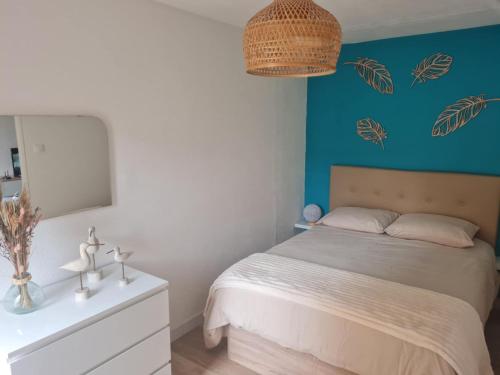 a bedroom with a bed and a blue wall at Le cocon Sétois - T2 et garage privé in Sète