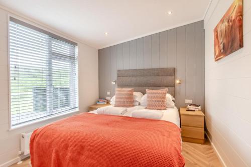 a bedroom with a large bed with an orange blanket at 2 Bed in Canaston Bridge oc-d34702 in Robeston Wathen