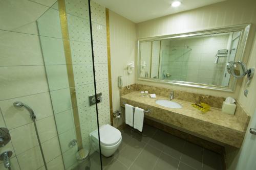 a bathroom with a sink and a toilet and a shower at Qafqaz Baku City Hotel & Residences in Baku