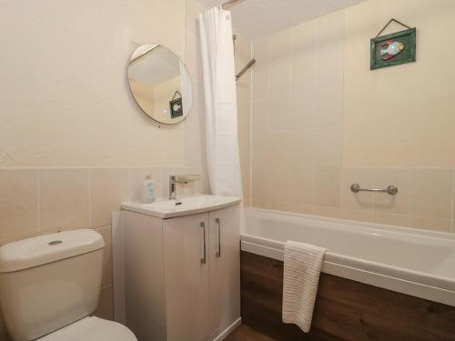 a bathroom with a toilet and a tub and a sink at Oak Tree in Weston-super-Mare