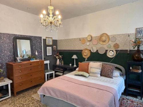 a bedroom with a bed and a mirror and a chandelier at La casa dei nonni in Bracelli