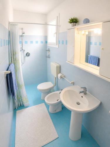 a blue and white bathroom with a sink and a toilet at Casa Francesca - Agenzia Cocal in Caorle