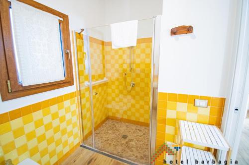 a bathroom with a shower with yellow tiles at Hotel Barbagia in Dorgali