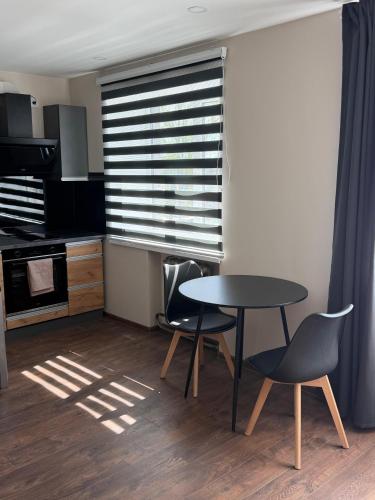 eine Küche mit Tisch und Stühlen und einem Fenster in der Unterkunft 5A Group in Līvāni