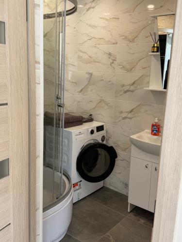 ein Badezimmer mit Waschmaschine und Waschbecken in der Unterkunft 5A Group in Līvāni