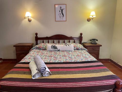 a bedroom with a bed with two towels on it at Casa los Molles Hostel in Maimará