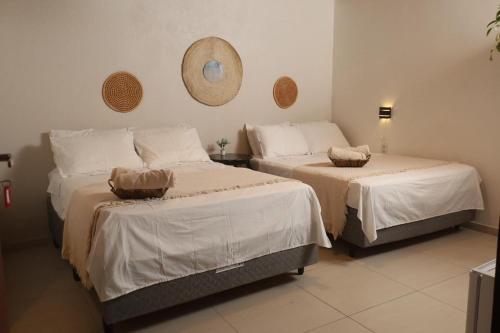 a bedroom with two beds and a mirror on the wall at Pousada Casa Boa Milagres a beira mar ideal para curtir a Rota dos Milagres in Barra do Camaragibe