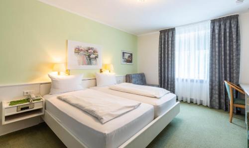 a hotel room with a bed and a window at Hotel Keller in Kreuztal