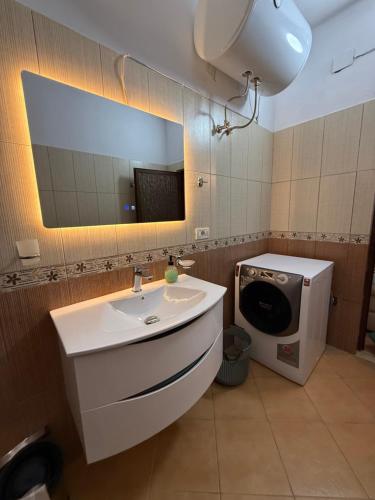 a bathroom with a sink and a washing machine at Xhoni House in Elbasan