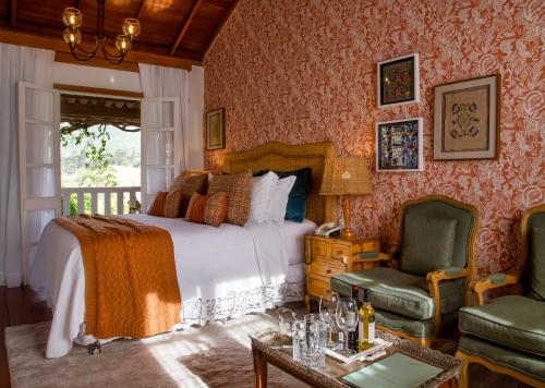 a bedroom with a bed and a chair and a table at Pousada Rabo do Lagarto in Pedra Azul