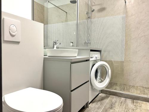 a bathroom with a sink and a washing machine at AVI GARDEN Apartments in Constanţa