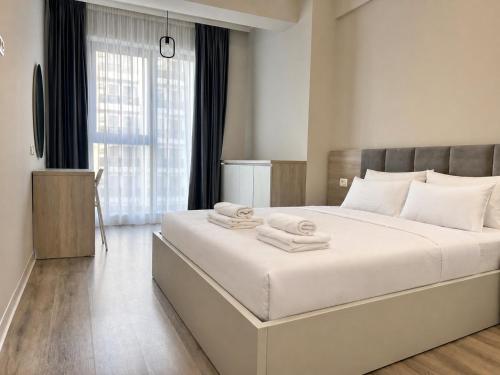 a bedroom with a large bed with towels on it at AVI GARDEN Apartments in Constanţa