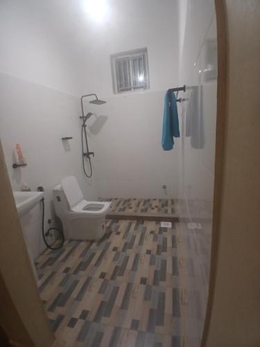 a bathroom with a toilet and a shower with a mirror at Sun house kendwa beach in Kendwa