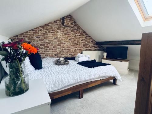 a bedroom with a bed with a vase of flowers at Lonsdale Terrace - 3 Bedrooms - Sleeps 6 in Workington