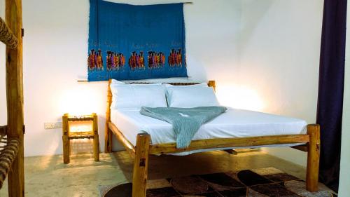 a bedroom with a bed with a blue painting on the wall at The Hub Train House Hakuna Matata in Zanzibar City