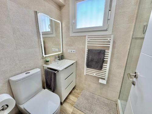 a bathroom with a toilet and a sink and a mirror at Apartamento Mart in Miami Platja