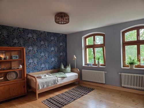 a bedroom with a bed and two windows at Apartment 2 im Martinsgarten Angermünde in Angermünde