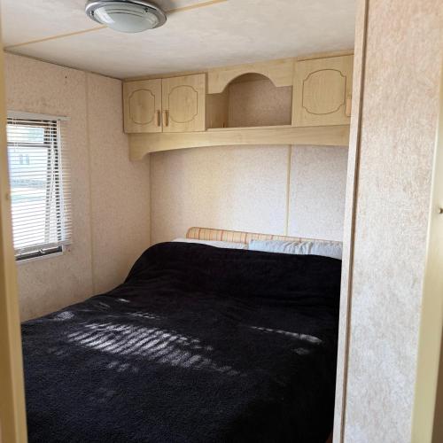 a small room with a bed in a caravan at Jackson Home from Home Holidays in Little Clacton