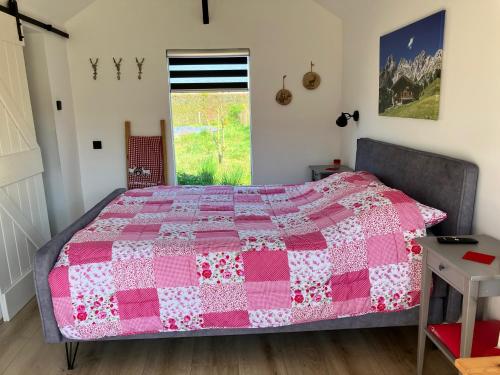 a bedroom with a pink and white quilt on a bed at 't Hûske in Venhorst