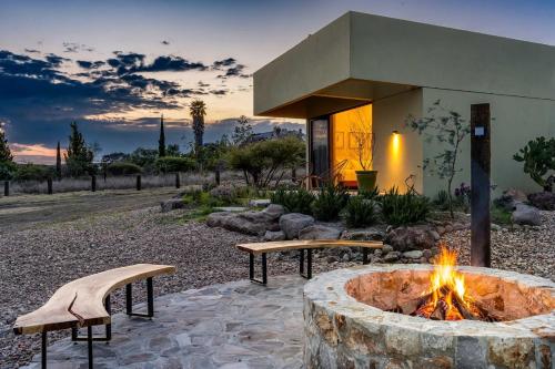 a fire pit with two benches in front of a building at Villa Lua, 2BR Countryside Bungalows for 6 Guests in La Talega