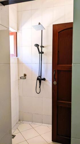 a bathroom with a shower with a glass door at The Hub Train House Hakuna Matata in Zanzibar City