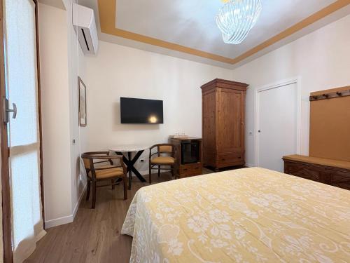 a bedroom with a bed and a table and a television at Alle porte di Spello in Spello