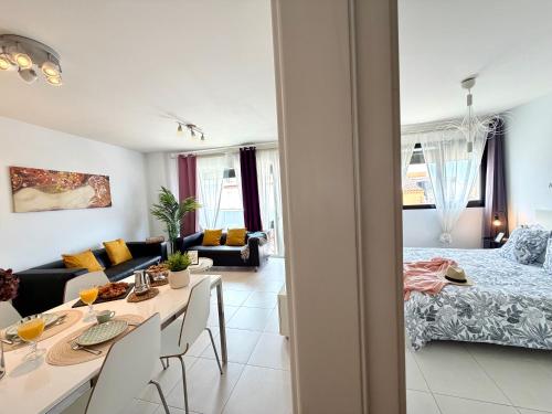 a living room with a bed and a dining room at Hortensia Suites Apartments, Los Cristianos, Tenerife in Los Cristianos
