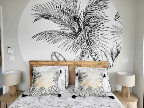 a bedroom with a bed with a black and white palm tree mural at Le léza - Terrasse et plage à 1 min in Les Trois-Îlets