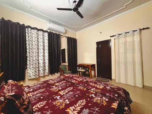 a bedroom with a bed and a ceiling fan at The Bel - Monte Stays in Panchkula