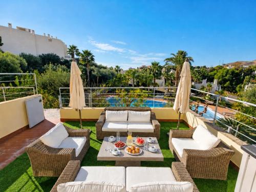 a patio with a table and chairs and a pool at Exquisite Costa Blanca Escape Townhouses in El Campello