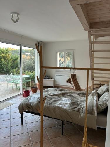 a bedroom with a bunk bed and a patio at LA BASTIDETTE PROVENçALE in Jouques