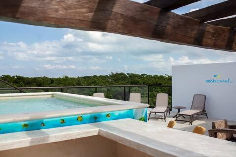 a large swimming pool with chairs and a table at Casa CooLas in Cozumel