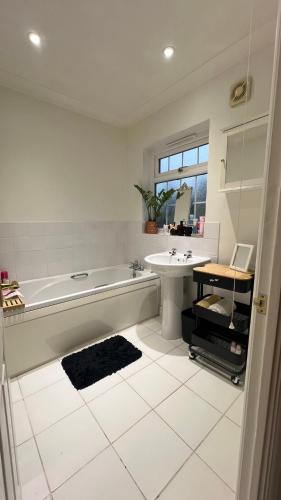 a white bathroom with a tub and a sink at Golden House in Waterbeach