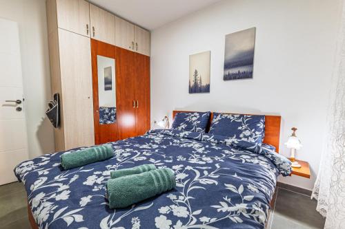 a bedroom with a blue and white bed with pillows at Apartman Goga 2 in Veliko Gradište