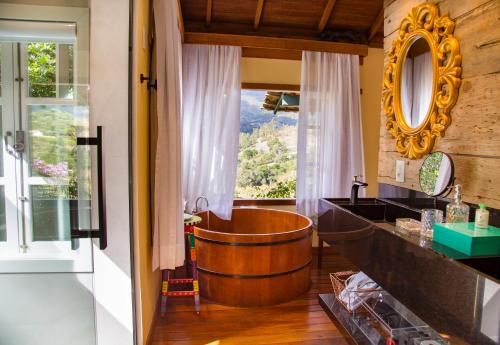 a bathroom with a wooden tub and a window at Pousada Rabo do Lagarto in Pedra Azul