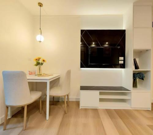 a dining room with a white table and chairs at Impact poppula P1 by เจี๊ยบ in Thung Si Kan