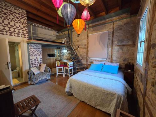 a bedroom with a bed and a staircase and lights at Homeric Poems in Chios