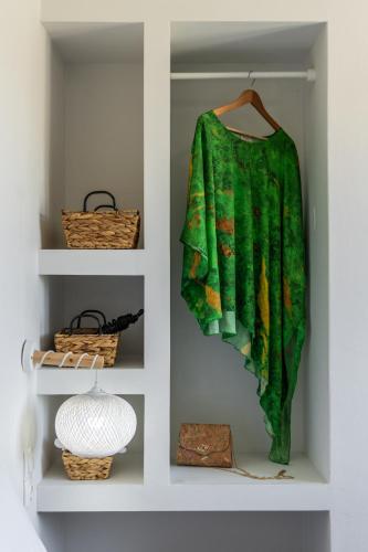 a green shirt is hanging in a closet at Artemis Cozy Home in Péran Triovasálos