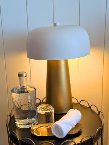 a table with a lamp and a towel and a bottle at Naval Guest House in Vila do Conde