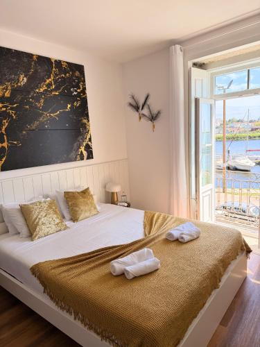 a bedroom with a bed with two towels on it at Naval Guest House in Vila do Conde
