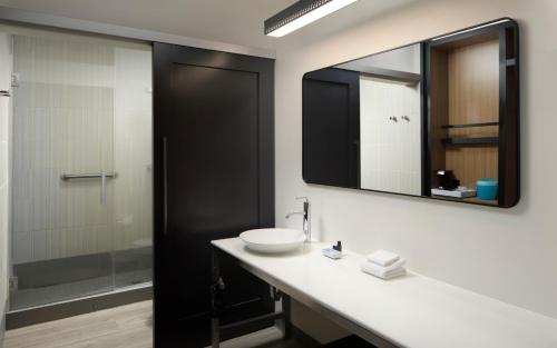 a bathroom with a sink and a mirror at Aloft by Marriott Arundel Mills BWI Airport in Hanover