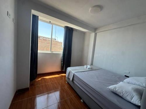 a bedroom with a bed and a large window at Mamá María Surf House in Puerto Chicama